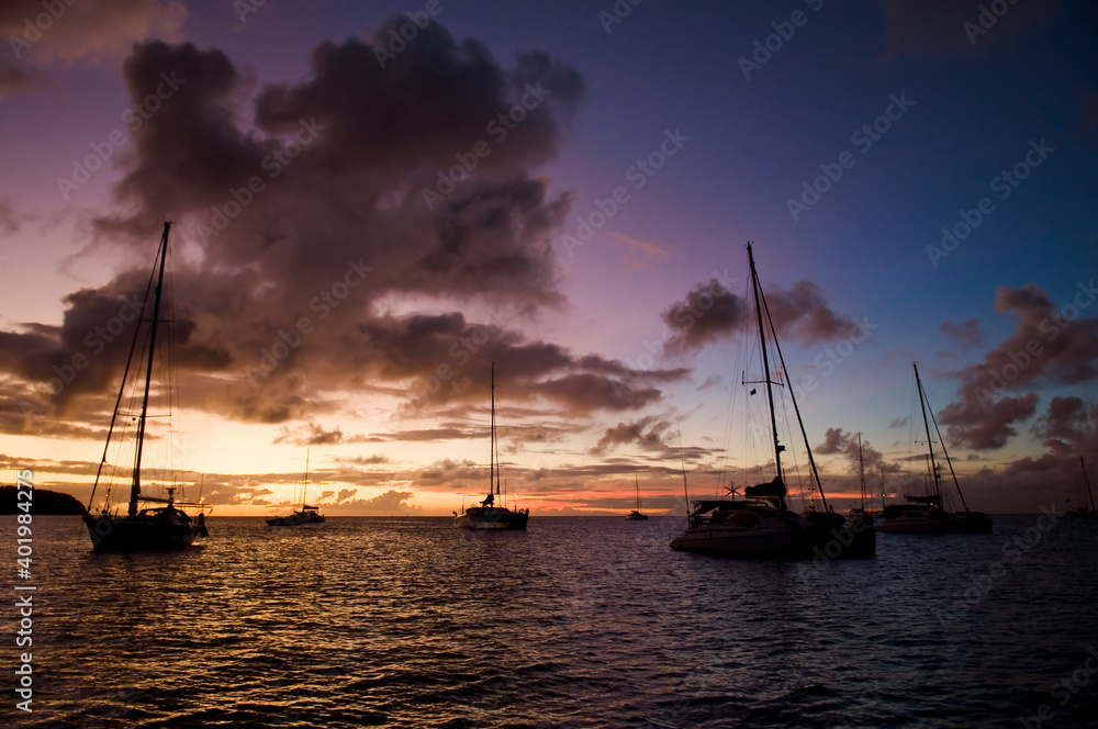 日落时在热带海湾停泊船只。黄昏时在海水上停泊小型游艇和双体船。San