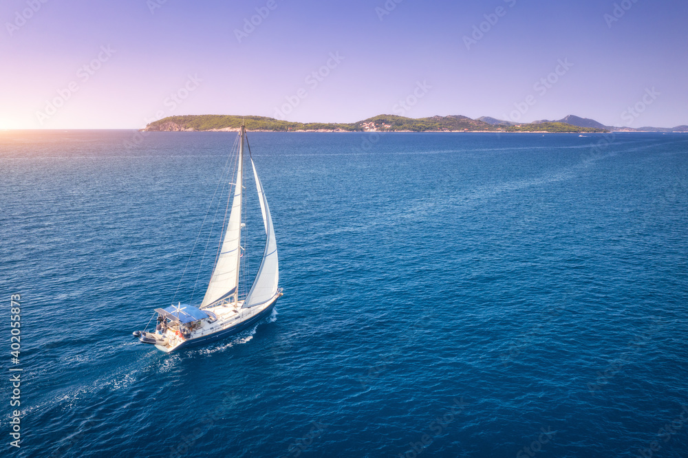 阳光明媚的夏夜，美丽的白色帆船在蓝色大海中的鸟瞰图。亚得里亚海在