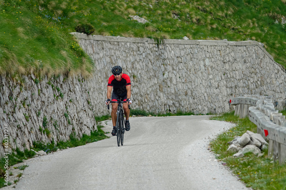 在斯洛文尼亚，一名运动员骑着自行车走上一条具有挑战性的山路。