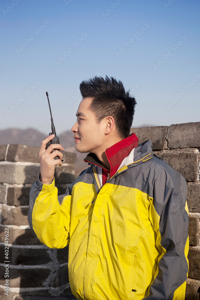 一个年轻人在长城旅游中使用对讲机