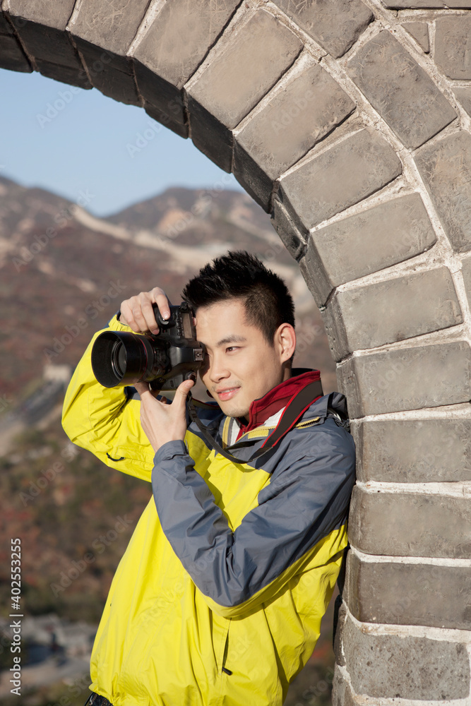 A young man to take photos in the the Great Wall Tourism 