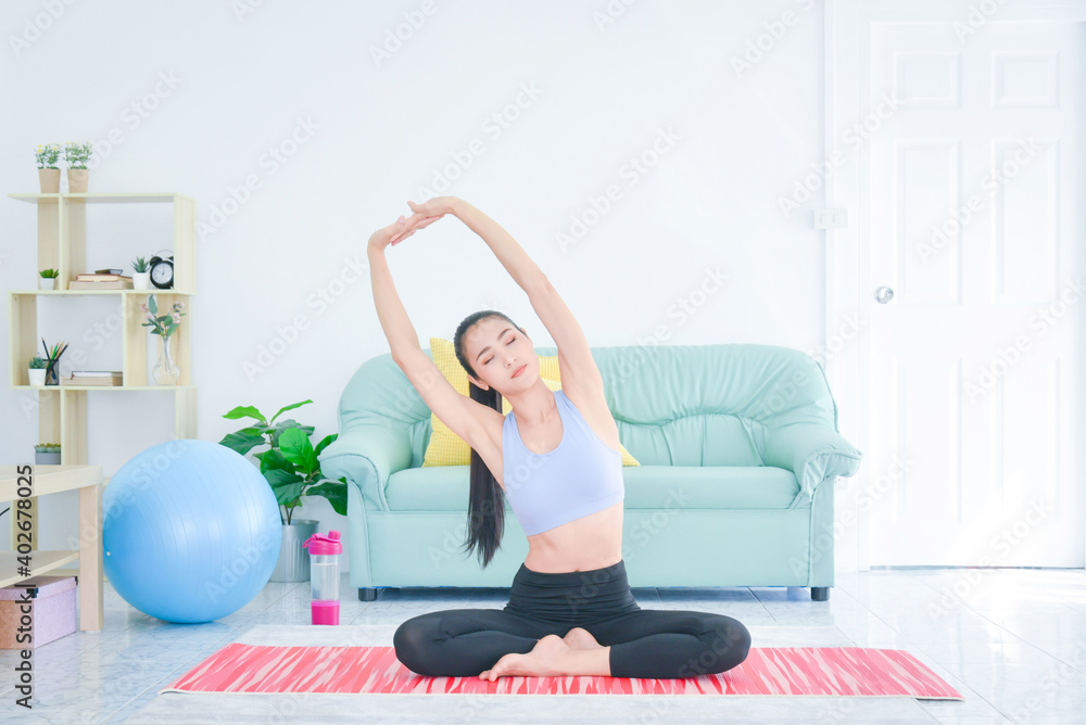 亚洲运动型年轻女性独自在客厅锻炼。在家锻炼。