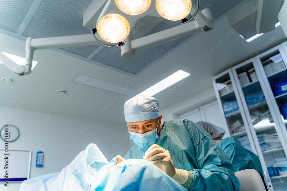 外科医生在现代诊所进行手术。专业整形外科医生在医院进行手术。