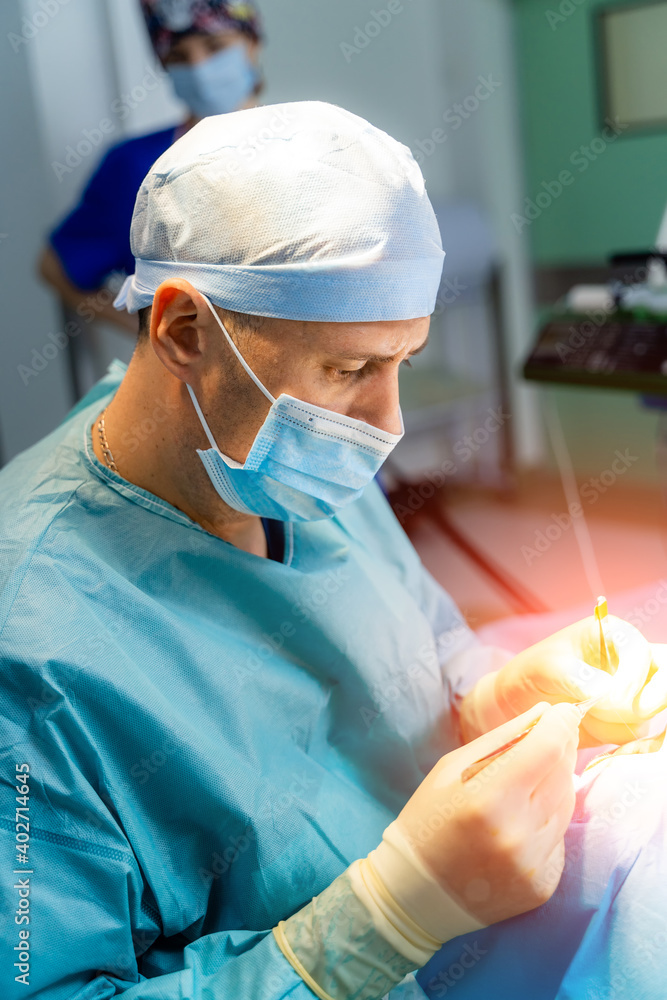 整形外科医生在医院手术室做整容手术。戴口罩的外科医生做医生