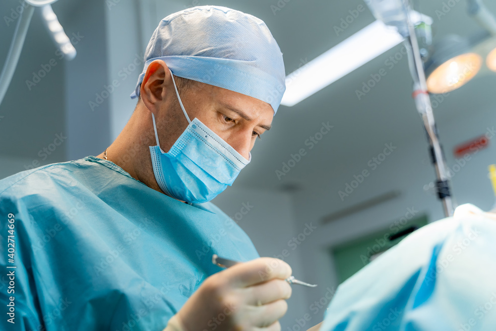 外科医生正在医院手术室进行整容手术。外科医生与患者一起工作。B