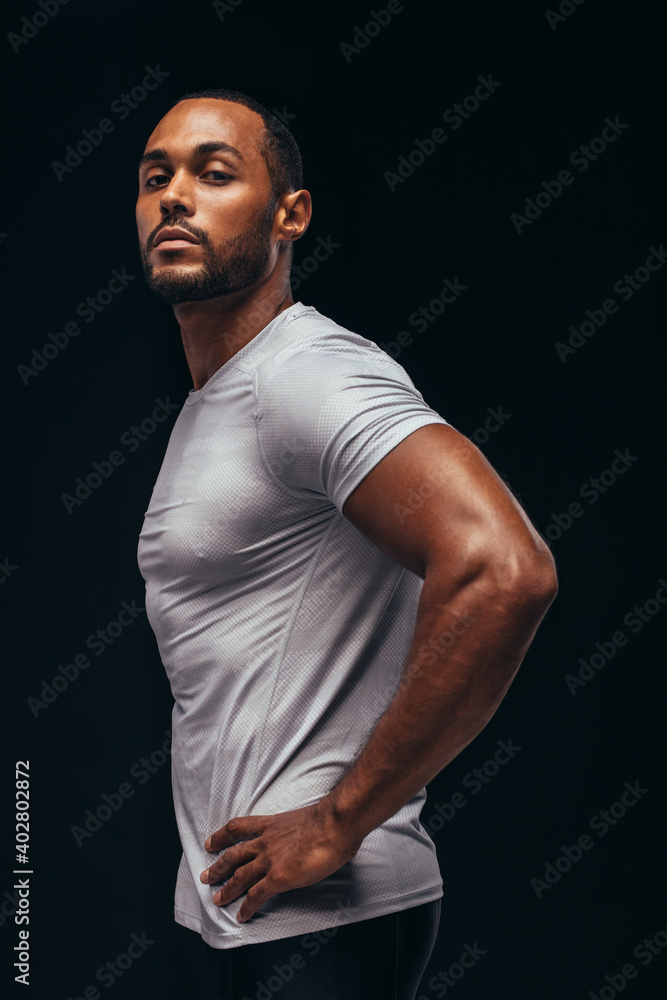 Side view portrait of a fit man on black background