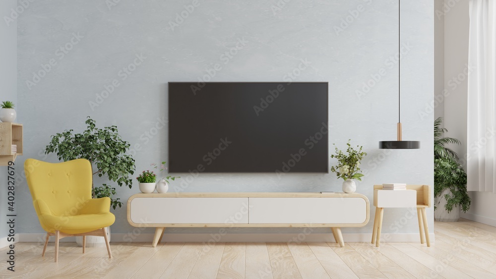 客厅蓝色墙上的智能电视，扶手椅，简约设计。
