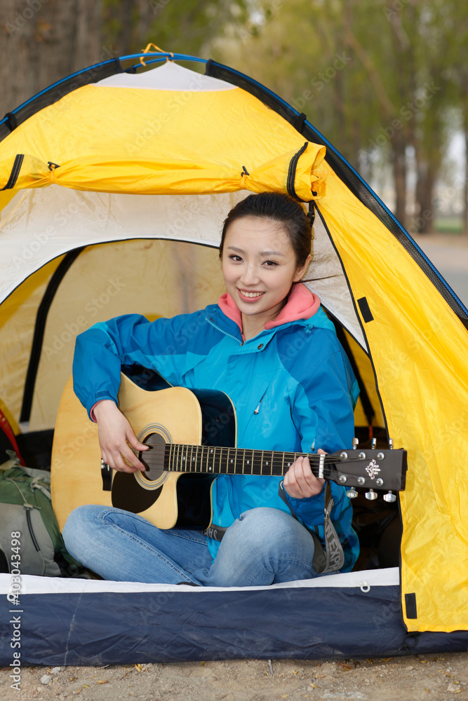那个年轻女人坐在帐篷里弹吉他