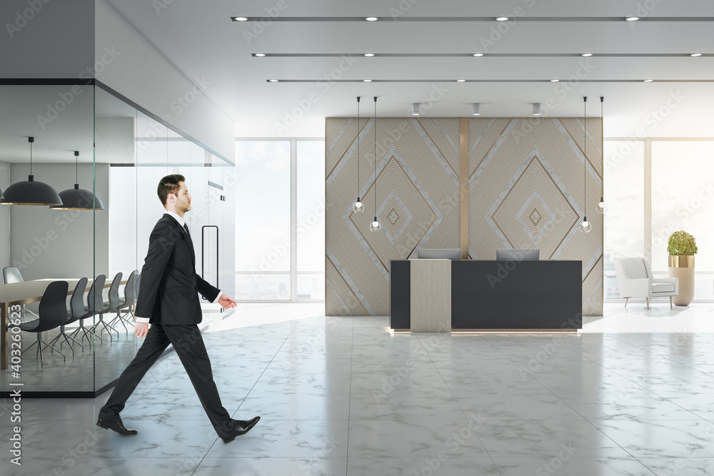 Businessman walking in luxury office lobby with reception