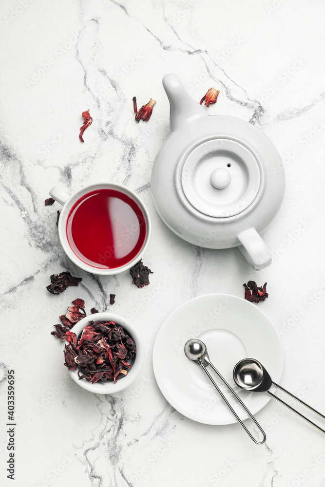 用茶壶和一杯木槿花茶在浅色背景下创作