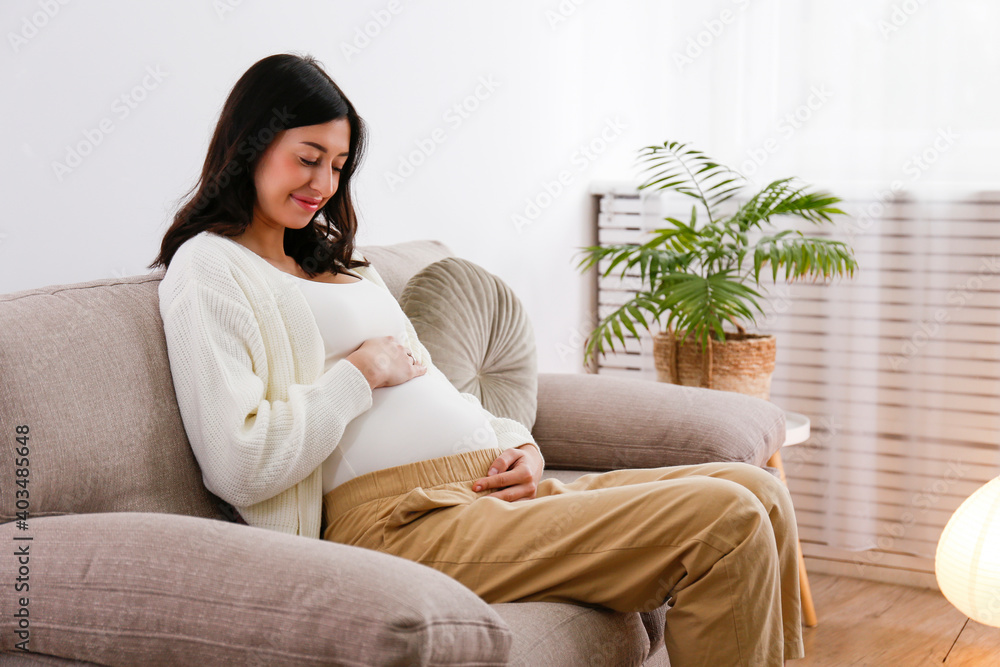怀孕中期的年轻漂亮孕妇坐在医生的沙发上休息