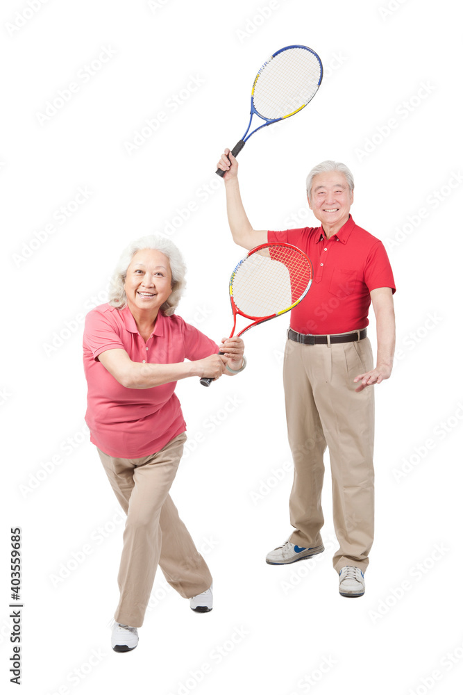 An happy old senior couple playing tennis rackets 