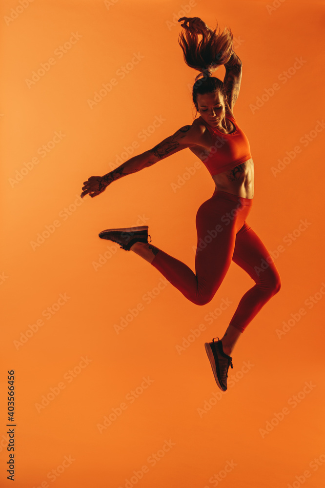 健身女性在锻炼时在空中跳跃的肖像