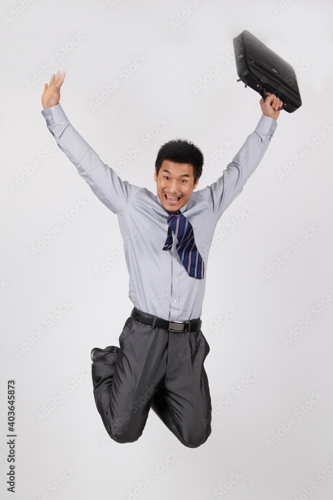 A young business man jumping with a briefcase