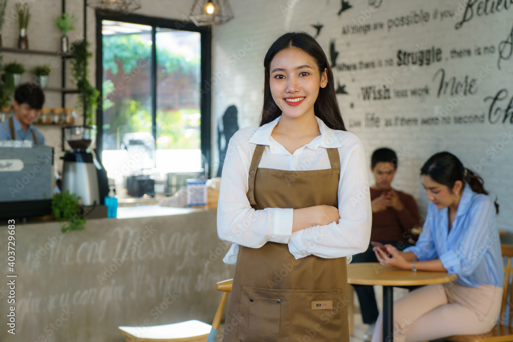 亚洲女咖啡师或小企业主穿着围裙看着摄像机准备提供咖啡服务