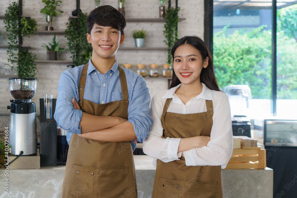 亚洲情侣咖啡师或小企业主穿着围裙看着摄像机准备提供咖啡服务