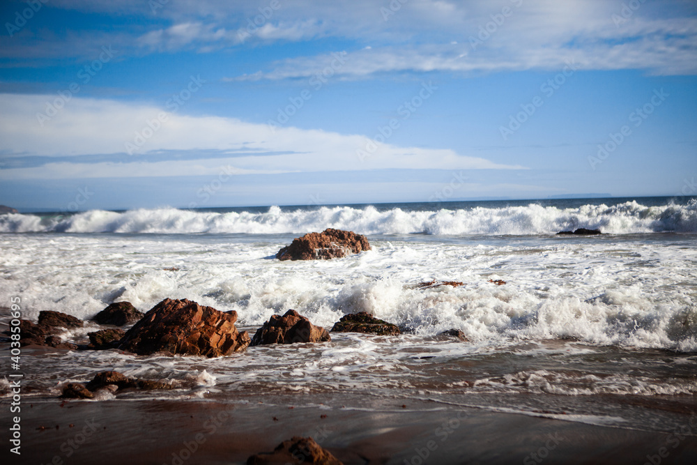加利福尼亚州大苏尔的海浪和金色日落，空气和海洋中有浪花