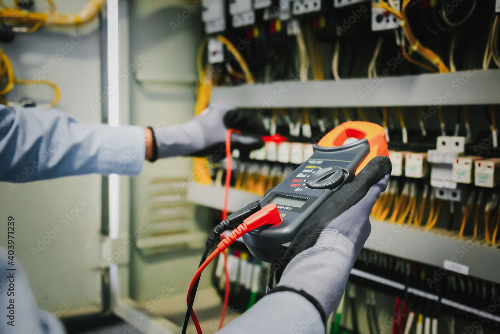 电气工程师测试保护继电器上的电气装置和接线，并对其进行测量