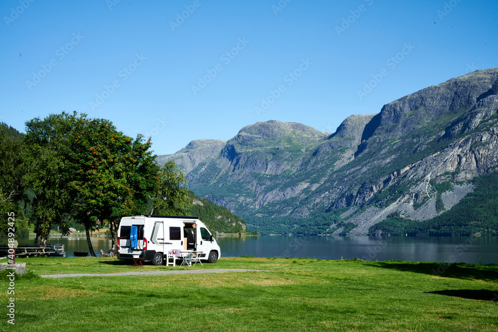 Wohnmobil auf einem sehr schönen Campingplatz mit Bergen in Hintergrund und See
