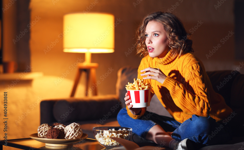 年轻女性吃薯条，看有趣的电影