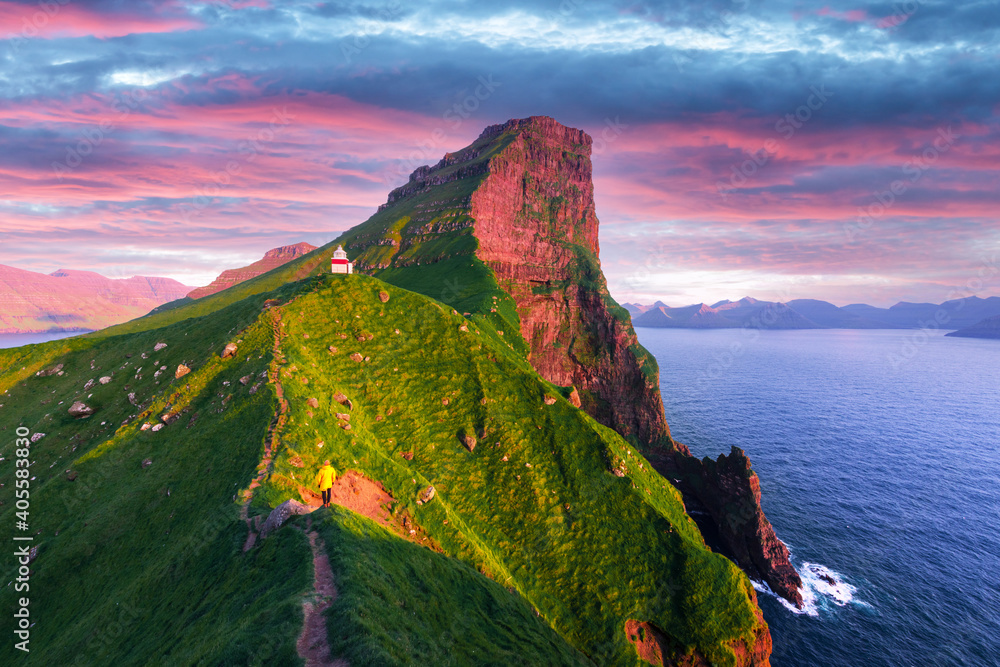 日落时分，丹麦法罗群岛卡尔索伊岛青山上的卡尔卢灯塔。景观