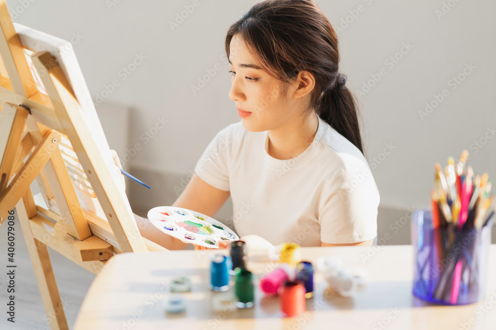 坐在地板上学习自己画画的年轻女孩