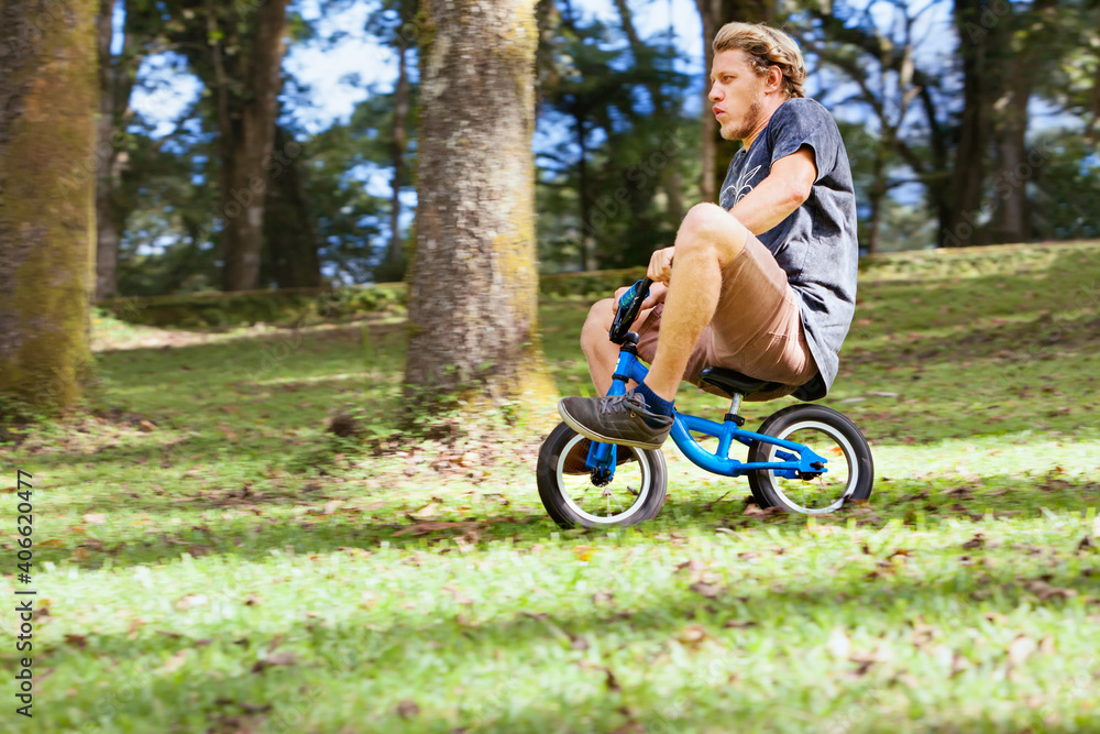 骑着小孩平衡自行车下坡很有趣。一个年轻的疯子从高山上骑下来。