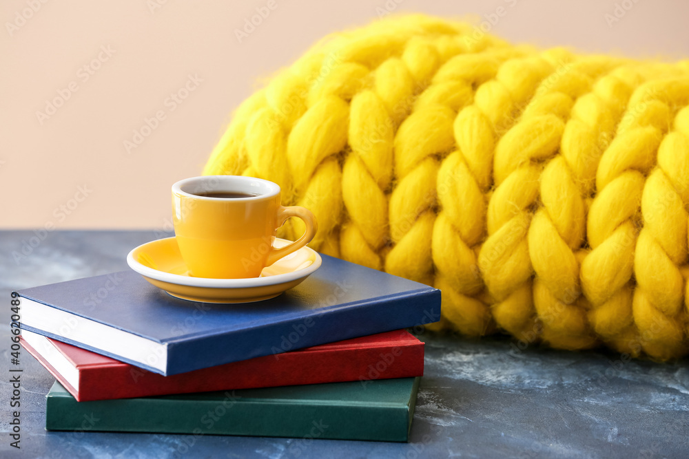 一杯咖啡，桌上有书和编织格子