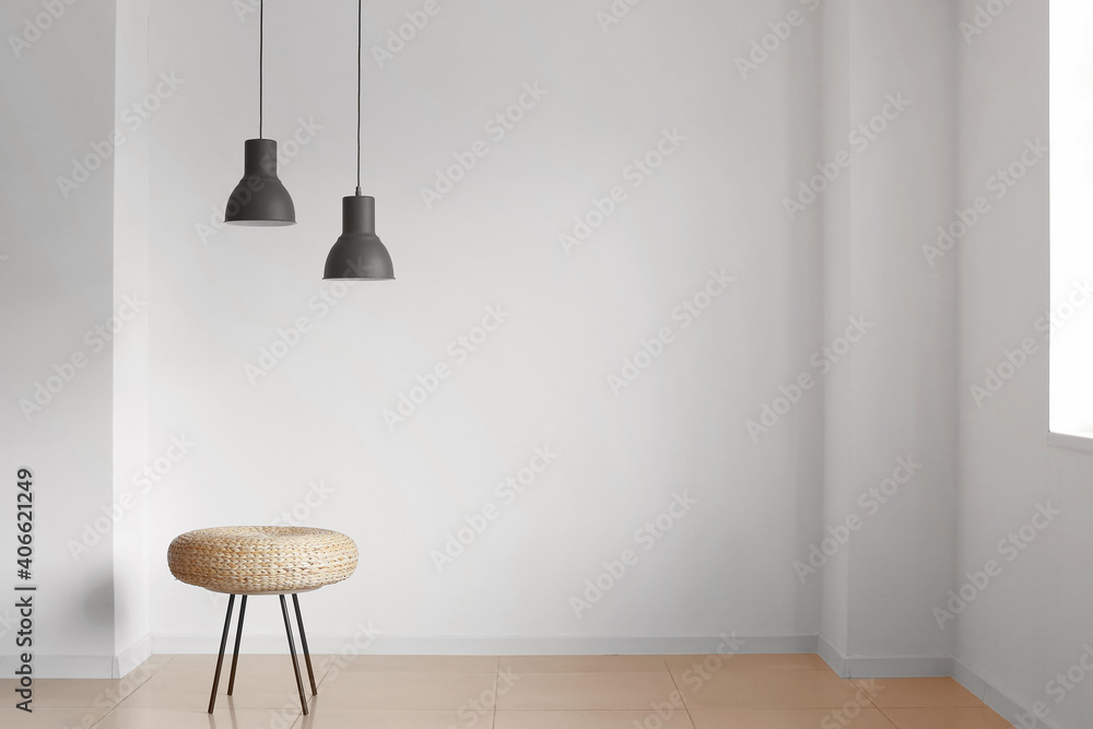 Pouf and lamps near light wall in room