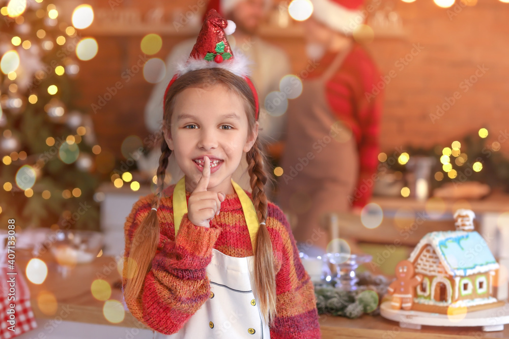 Little girl showing silence gesture in kitchen on Christmas eve