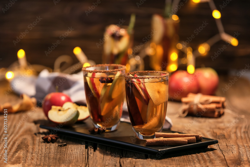 晚上在木桌上用玻璃杯装着香料和苹果片的美味饮料