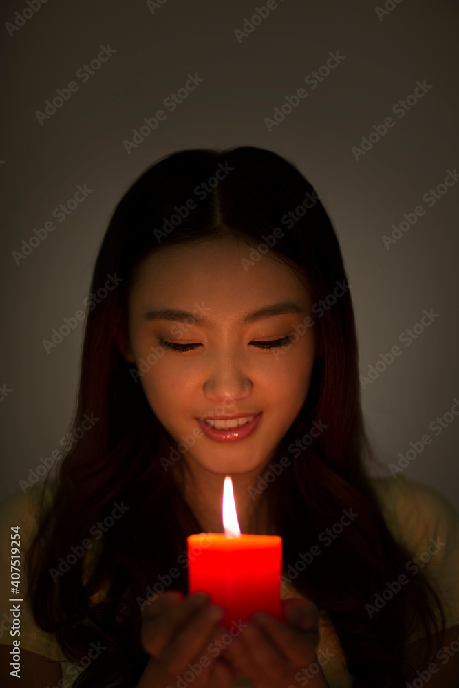 手持红色蜡烛的年轻女子