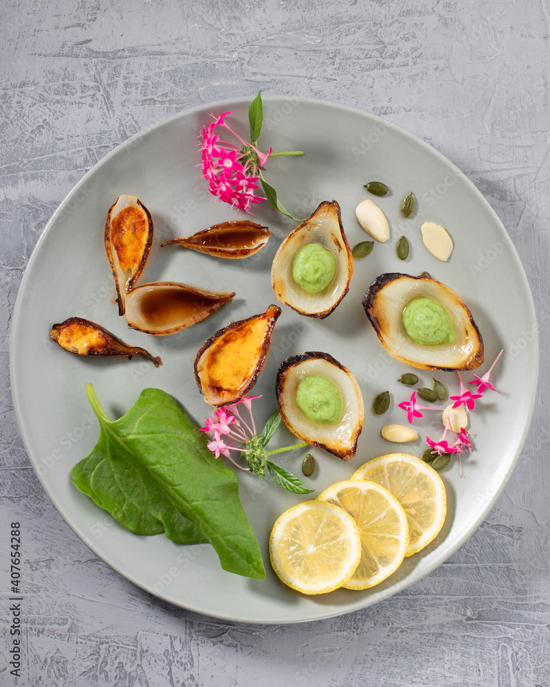 用蔬菜和叶子做成的盘子里五颜六色的食物艺术构图。俯视图。