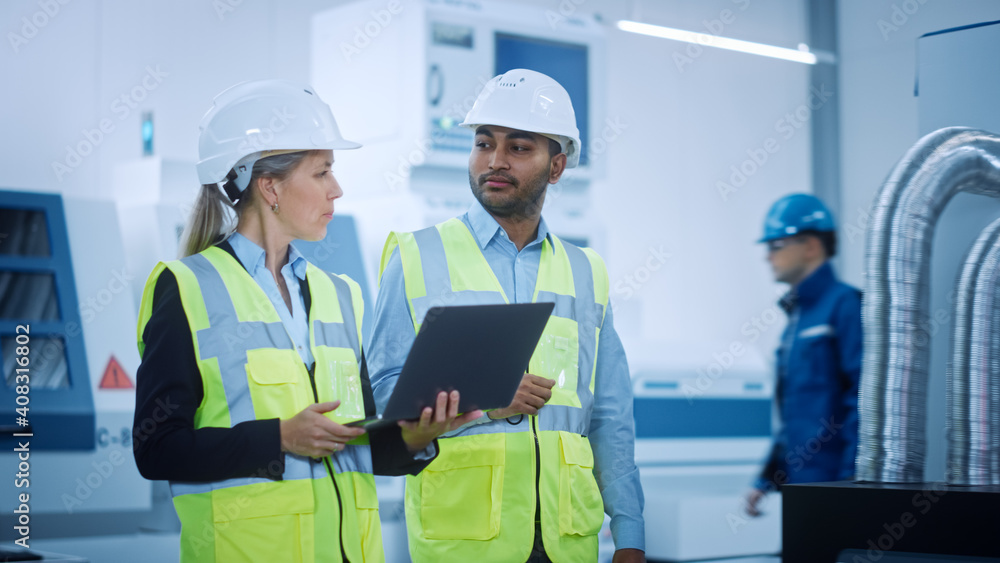 Chief Engineer and Project Manager Wearing Safety Vests and Hard Hats Walk Through Modern Factory, T