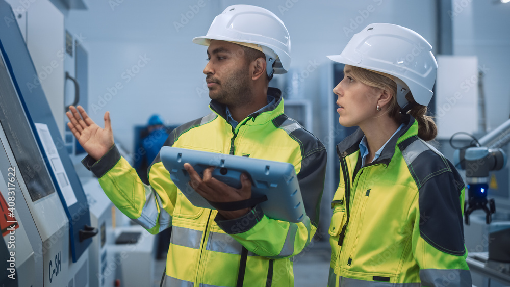 总工程师、项目经理穿着安全背心、戴着安全帽，使用数字平板电脑控制器