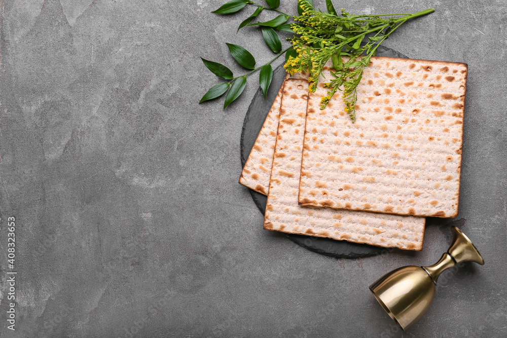 逾越节用犹太扁平面包垫和灰色背景的杯子