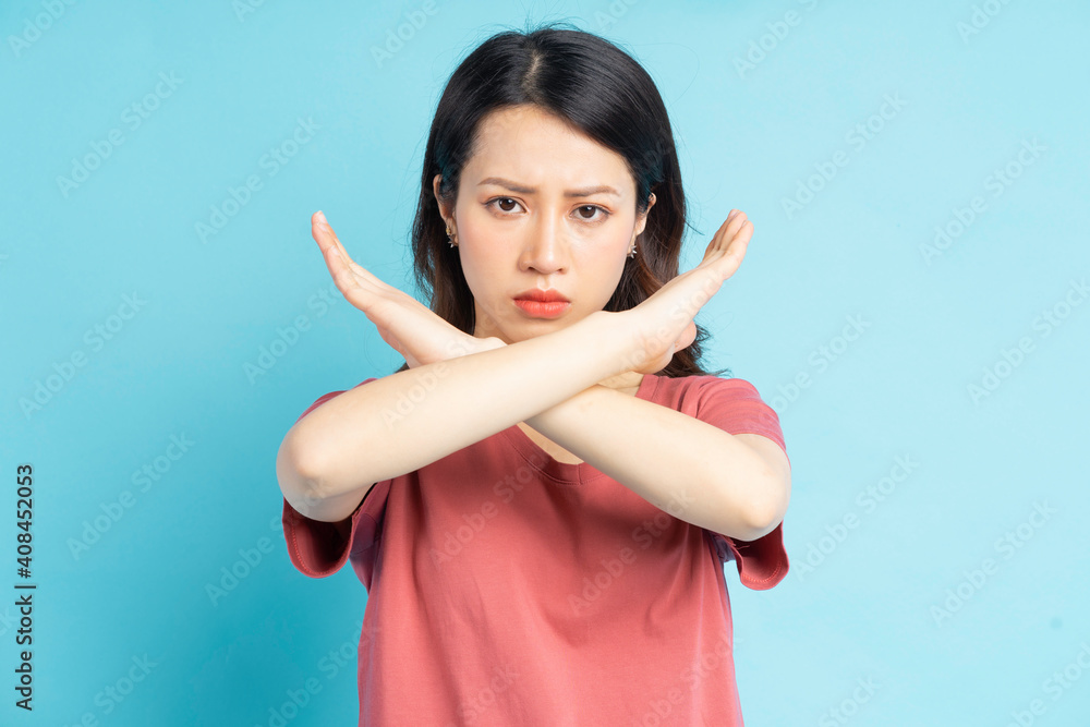 Beautiful Asian woman making an X by hand with an angry face
