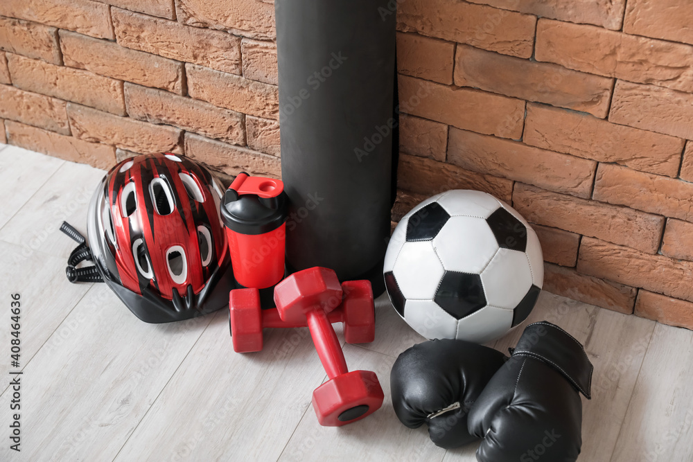 Set of sports equipment on floor near brick wall