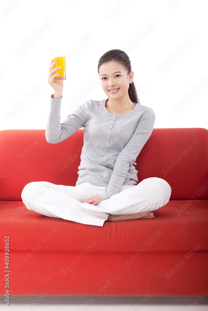 Oriental fashion female holding a glass of orange juice