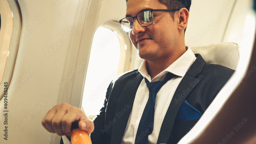 商人在飞机上由空姐供应橙汁。商务旅行的概念。