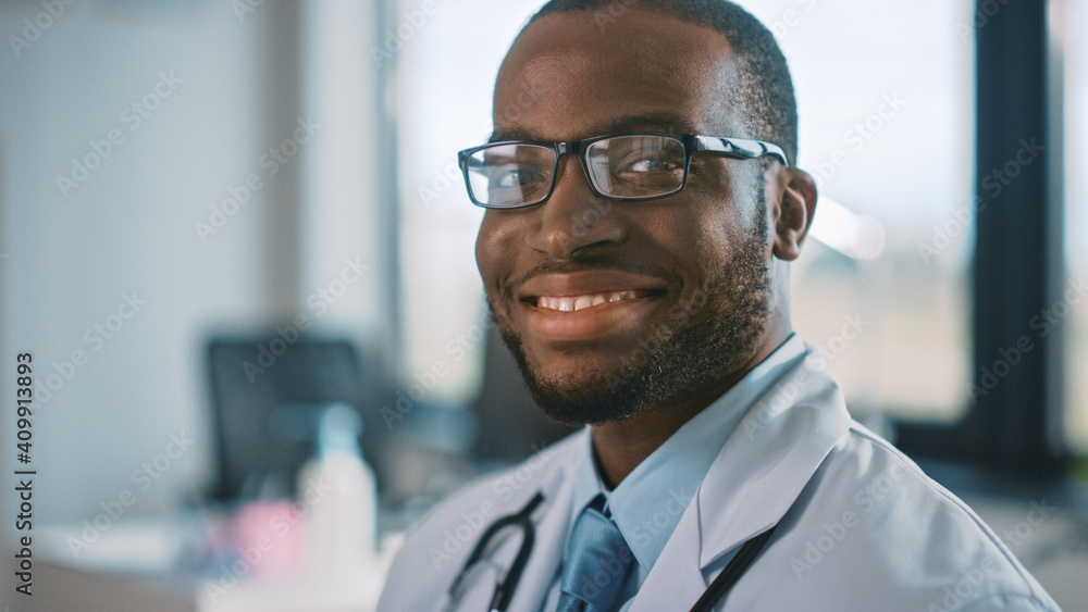 戴眼镜的非裔美国家庭医生在健康诊所工作的肖像。成功
