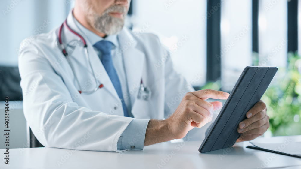 一位家庭医生在健康诊所使用平板电脑的特写。医生在华盛顿