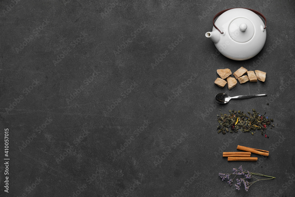 以茶壶和干茶叶为背景的深色构图