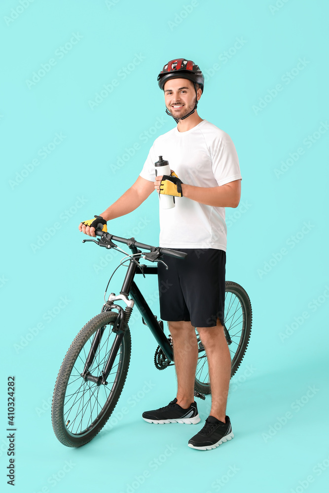 男自行车手，彩色背景上有一瓶水