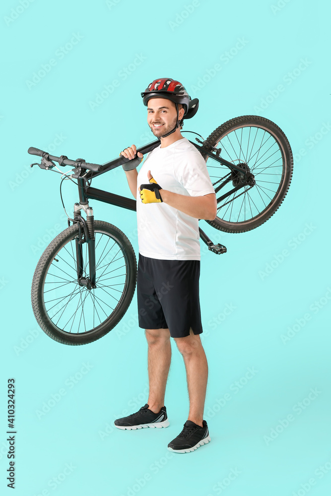 骑自行车的男性在彩色背景上竖起大拇指