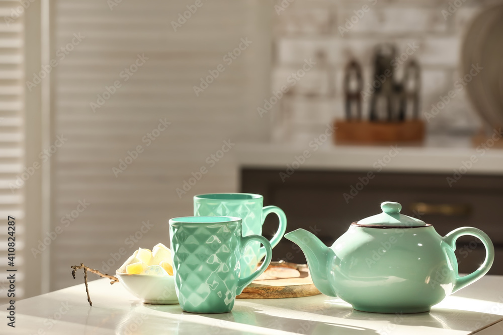 房间浅色桌子上的时尚茶壶和杯子