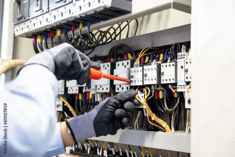 Electricians work to connect electric wires in the system, switchboard, electrical system in Control