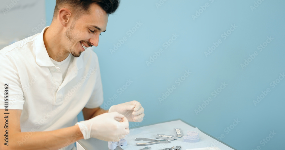 牙科技术人员正在与一个牙齿模型一起尝试正畸治疗支架系统a