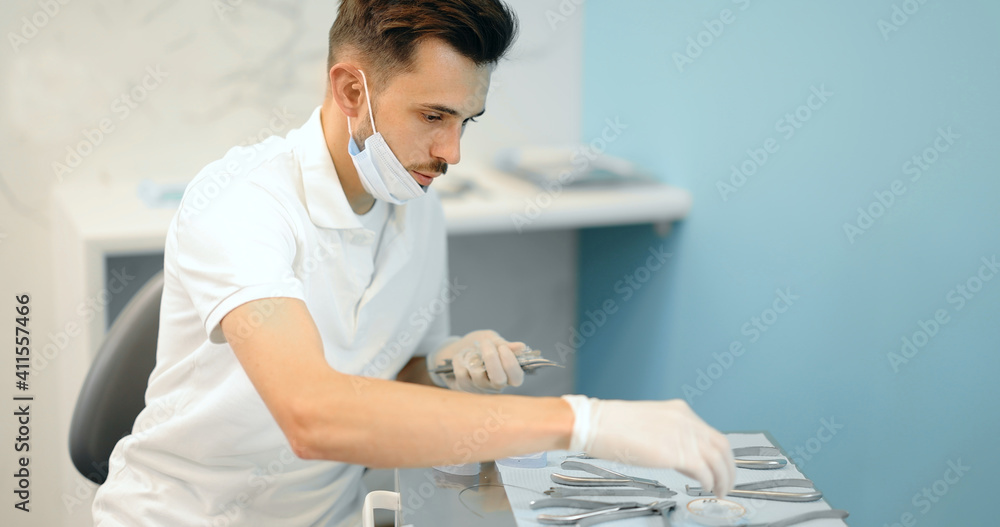 Dental technician working with a model of teeth trying on a brace system for orthodontic treatment a