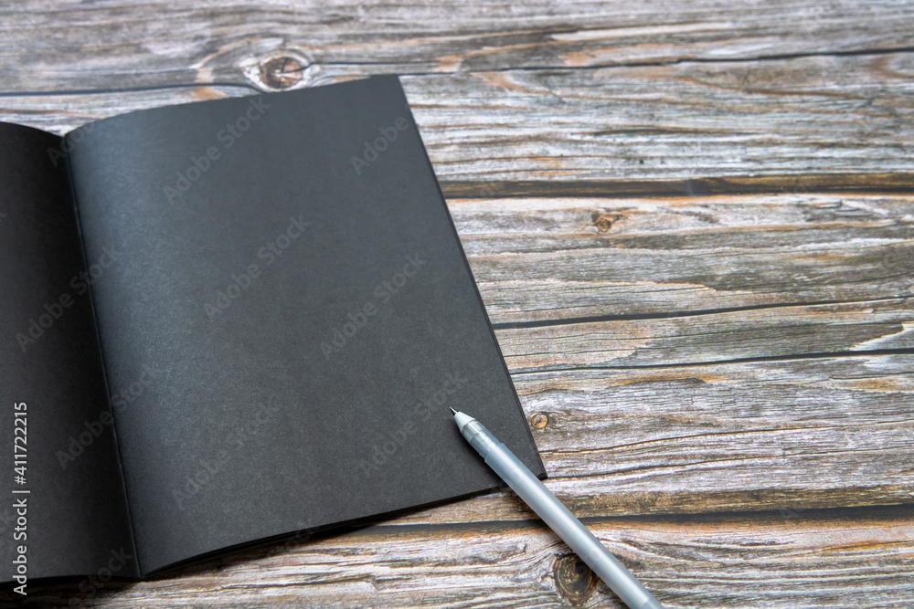 Blank black book and white pen on wooden table background, Black book on wooden table, Top view, cop